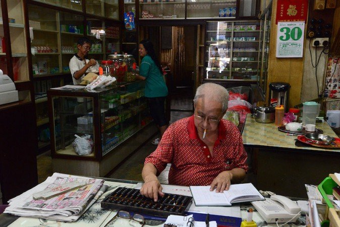 Yoo Chian Hooi seen calculating his traditional Chinese medicine shop's account at Bukit Mertajam in Penang on March 30, 2015. (Photo from The Malaysian Insider, pic by Hasnoor Hussain)